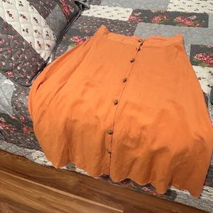 An orange button down mid calf full skirt with sash